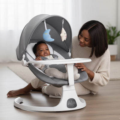 Bébé assis dans un lit de bébé à bascule électrique gris avec canopy, attaché avec une ceinture de sécurité à cinq points, pendant que sa maman sourit à côté
