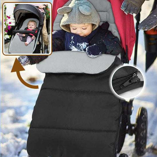 Bébé confortablement installé dans une chancelière coupe-vent grise épaisse, fixée sur une poussette, lors d'une promenade en hiver-sphere de maman-nourrison