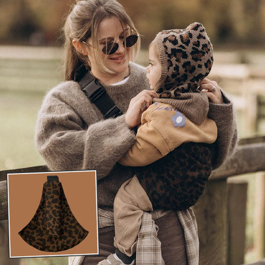Porte-bébé ergonomique motif léopard avec assise intégrée, porté par un parent souriant en promenade avec son bébé-sphere de maman-nourrison